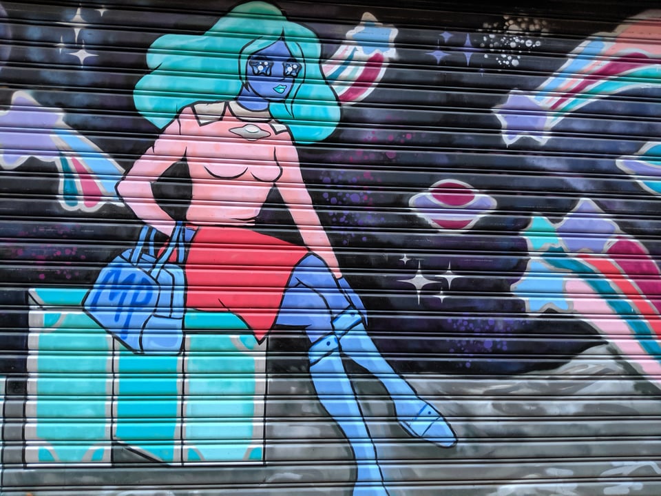 Blue haired, blue-skinned lady sitting on an alien planet holding a big purse, with a red skirt and a nice pink sweater. The sky is full of swirling stars
