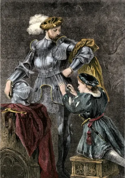 A squire helps fasten a knight's armor.