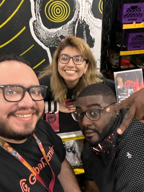 three people posing for a photo at a convention