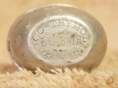 Antique Aluminum eye cup labeled "Glyco-Thymoline Eye Bath"