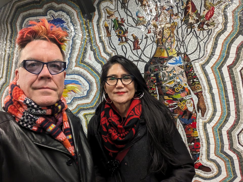 Blake & Asako standing in front of Nick Cave mosaic murals