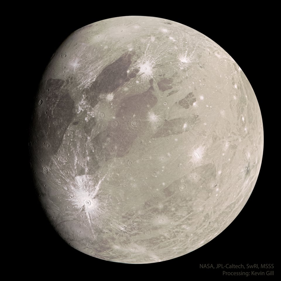 A grayish-brown moon with bright white ice expoed by meteor impacts