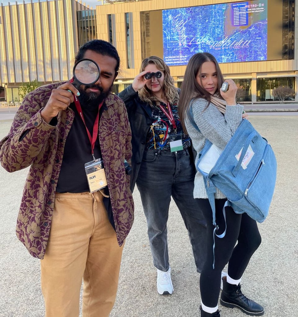 Three people wearing conference badges holding investigation tools.