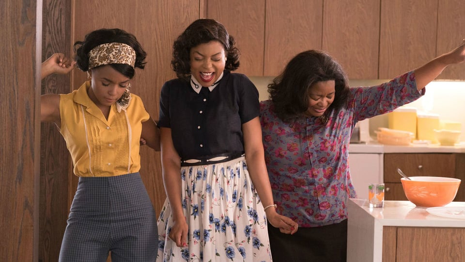A scene from Hidden Figures with the three female protagonist dancing