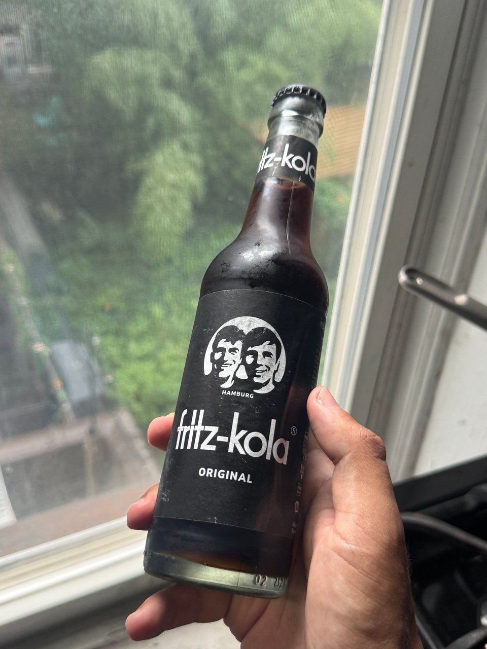 a bottle of Fritz-kola from Hamburg, Germany. The logo on the otherwise black label is a photo of the creators of the soda, smiling together.