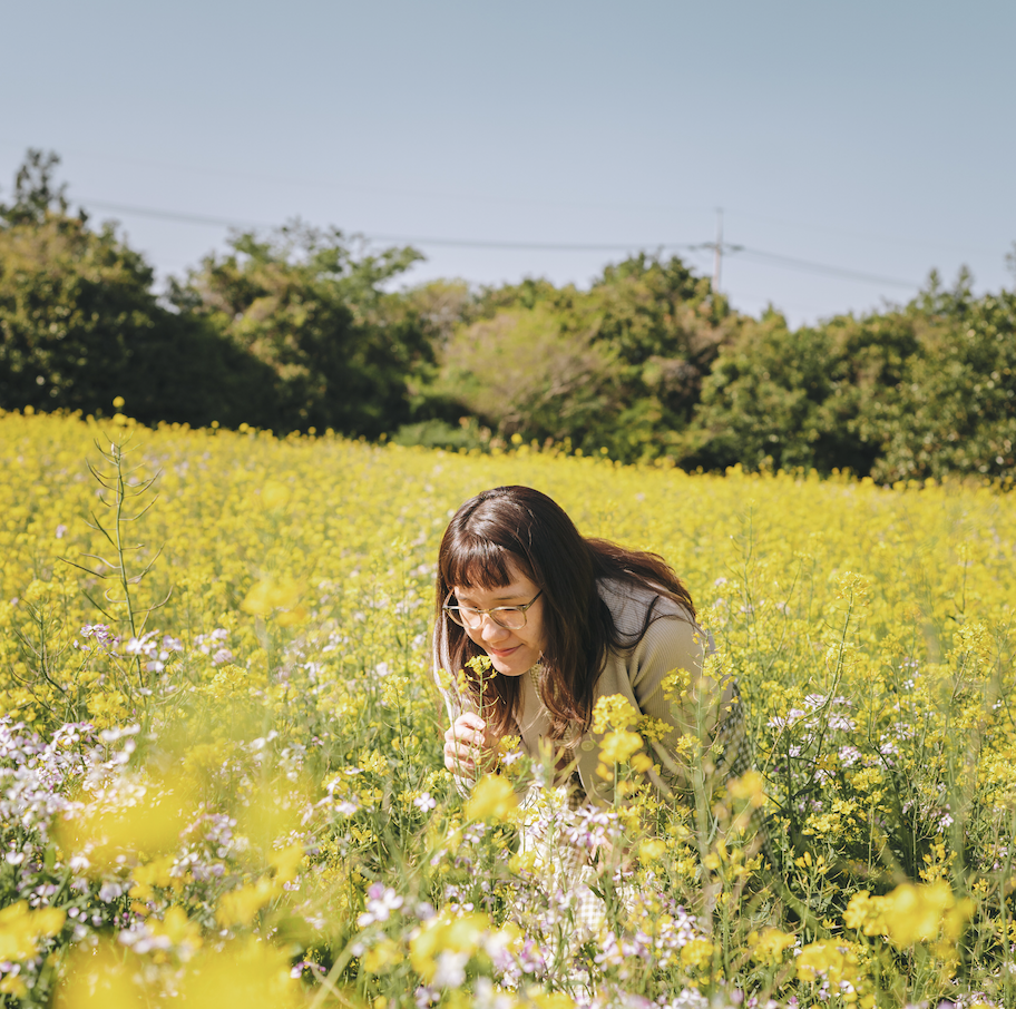 Female in a field of canola flowers
