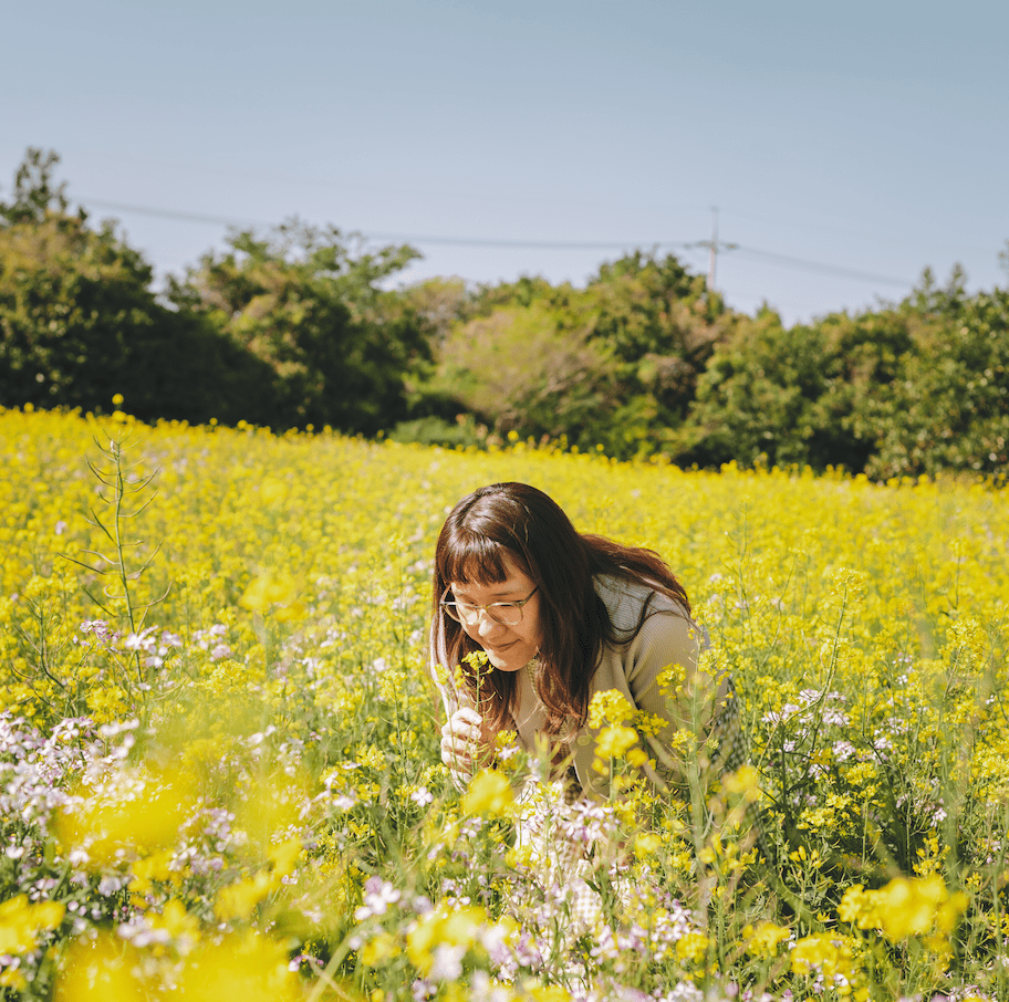 Female in a field of canola flowers