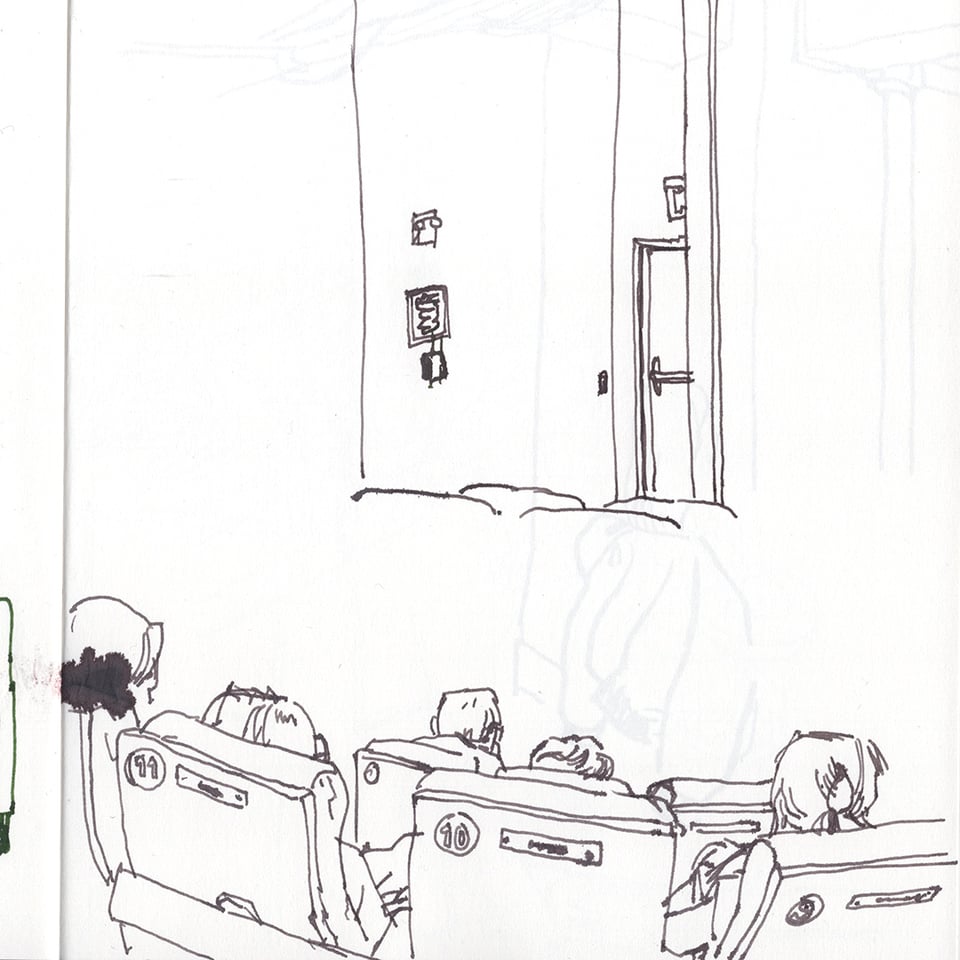 sketch of an emergency exit near the stage, and rows of seated people with a blotch of ink