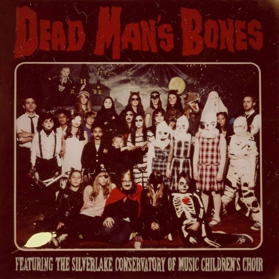 An album cover for Dead Man's Bones, featuring The Silverlake Conservatory of Music Children's Choir. It shows a group shot like a class photo of people wearing Halloween costumes.