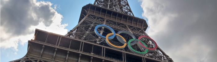 Looking up at the middle of the Eiffel Tower, with Olympic rings attached