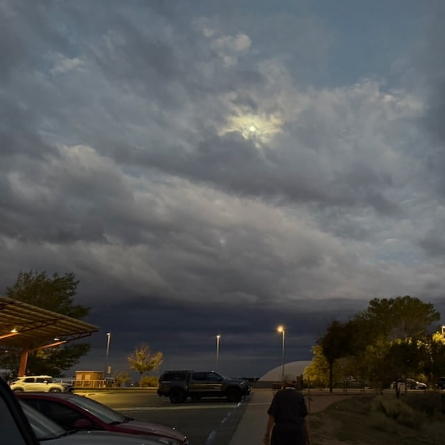 At dawn in parking lot of a Santa Fe gym, layers of clouds dominate the sky as storm approaches from the west.