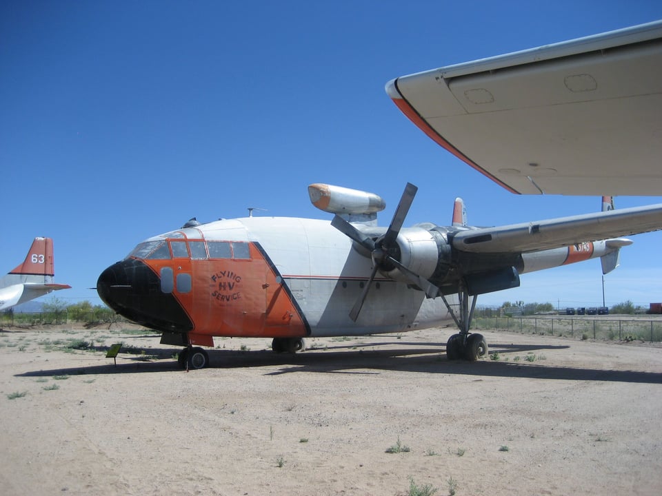 A red and white propeller plane that is shaped more like a helicopter.