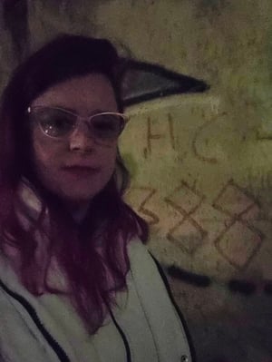 Extremely blurry photo of Meredith at the Berlin Wall, taken at night.