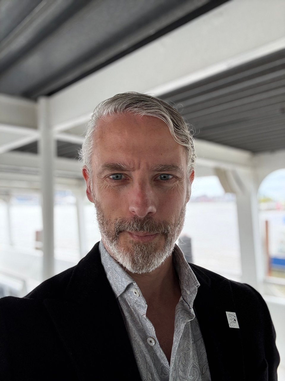 Photo of let’s be honest good-looking silver fox white man wearing a black corduroy suit and a light green paisley dress shirt
