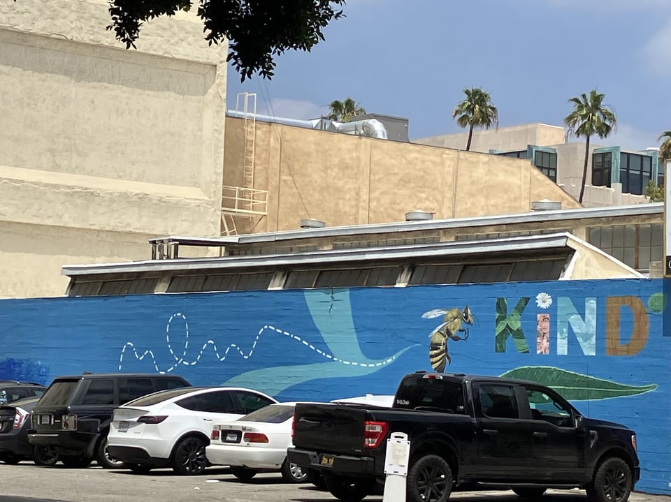 Graffiti with a bee and the word "KIND" next to it.