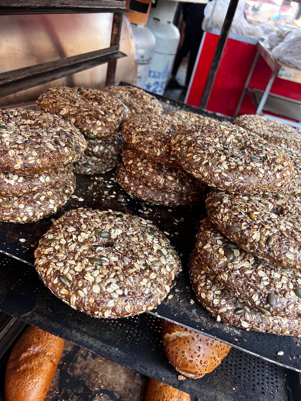 Flat whole grain rolls with a hole in the center, with oat flakes and seeds