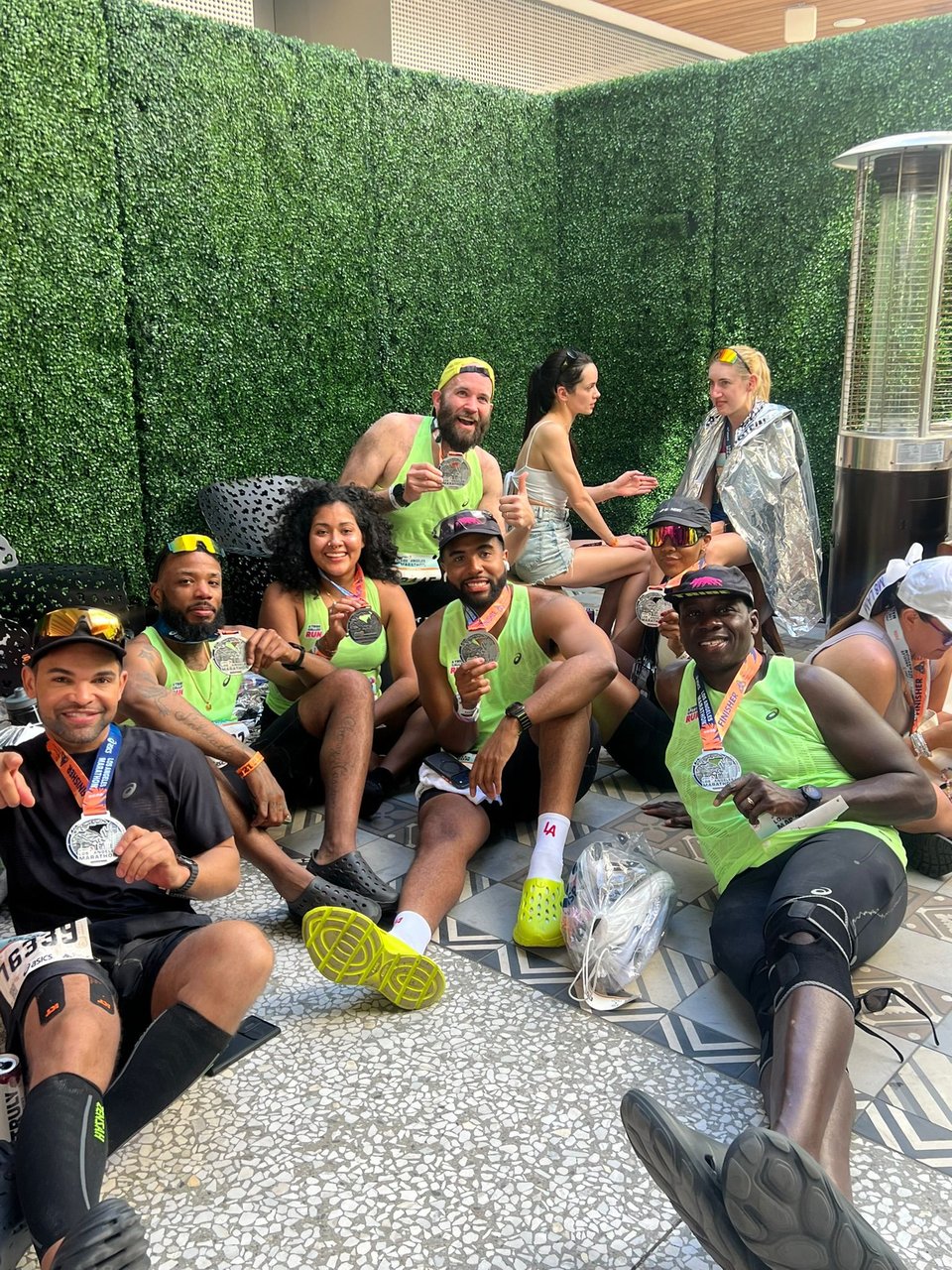 A group of people holding their finishers medals from the LA Marathon.