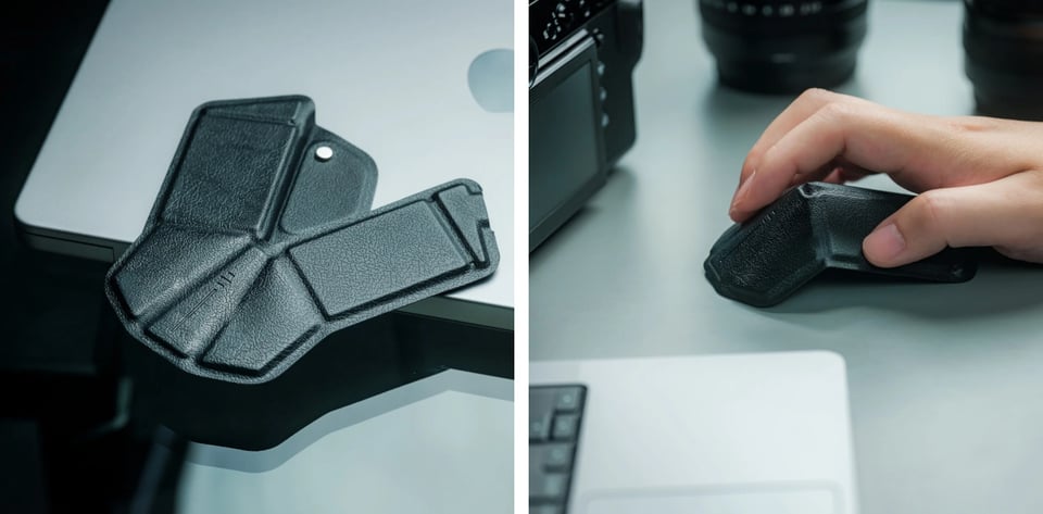 Two photos showing the origami mouse. On the left, the mouse is in its flat state. It appears to be made of some sort of soft fabric that almost looks like black leather, and it is roughly in the geometric shape of a large fly or cicada. On the right is a photo of the mouse folded up into its mouse form, and a man's hand is poised over it, one finger, clicking the button. A laptop can be seen in the corner of this second photo.