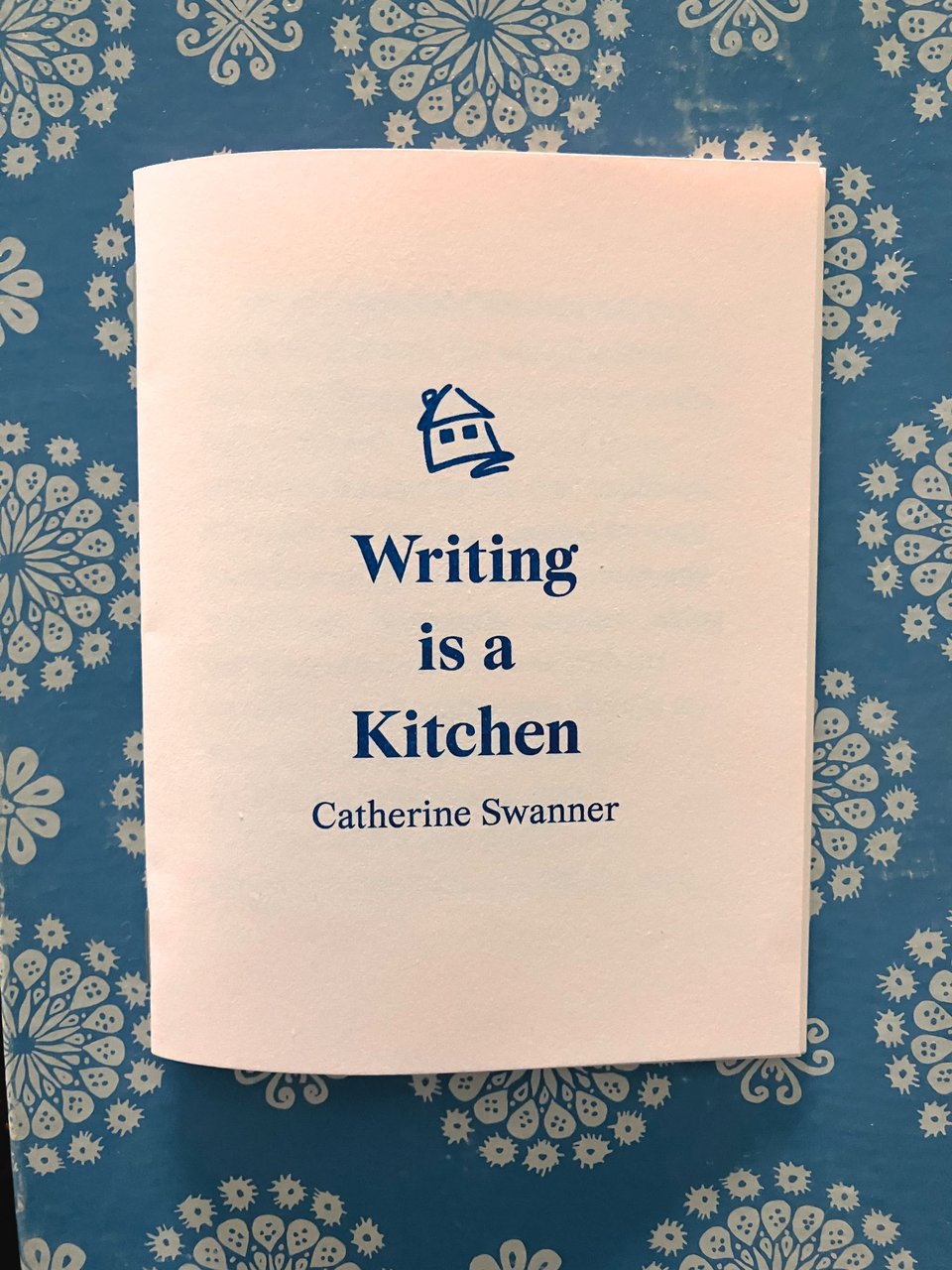 small pink booklet on blue background