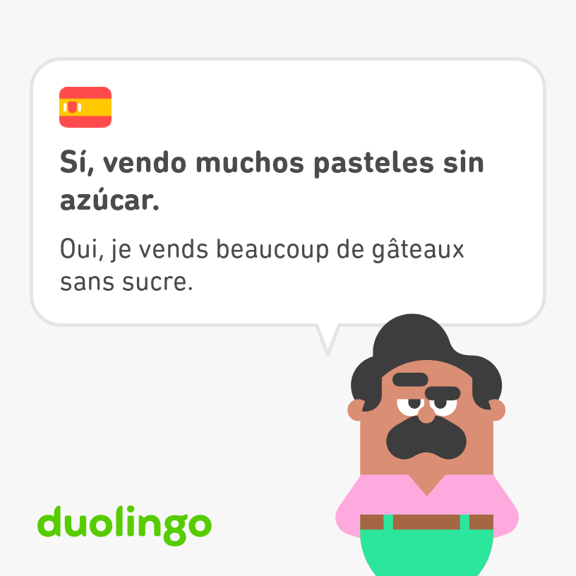 Oscar, mustachioed art teacher from Duolingo, wears his signature pink shirt, green pants and brown belt as he says, "Yes, I sell a lot of cakes without sugar," in French and Spanish.