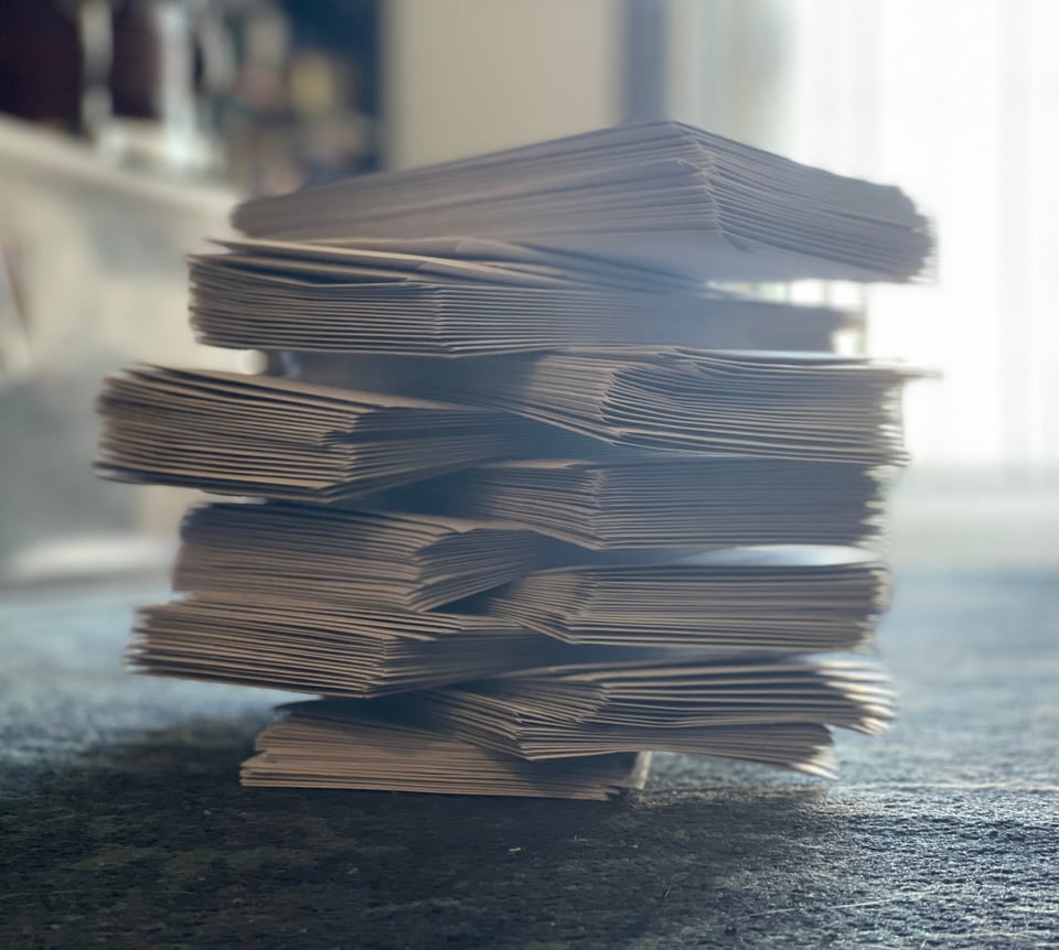 A stack of letters piled up on a carpet, a blurry apartment in the background