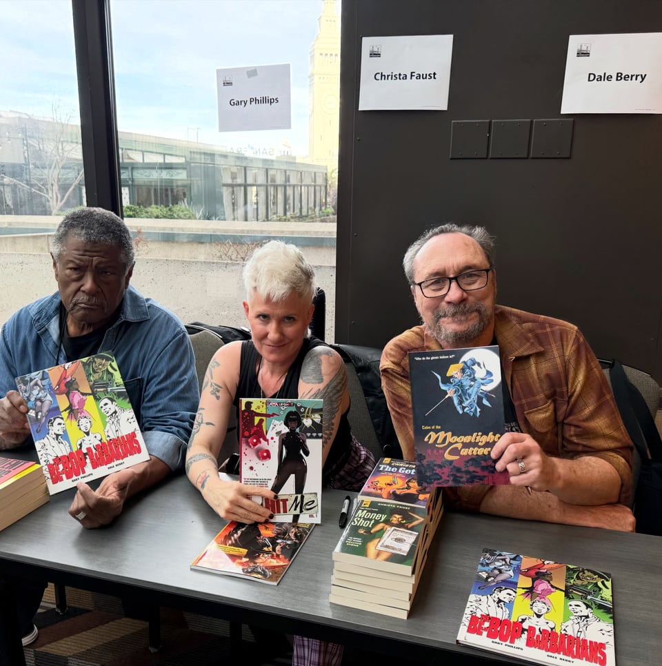 Gary Phillips, me and Dale Berry holding up comics at the post-panel signing table.