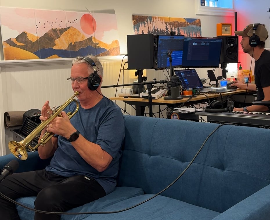 a man playing a trumpet in a recording studio