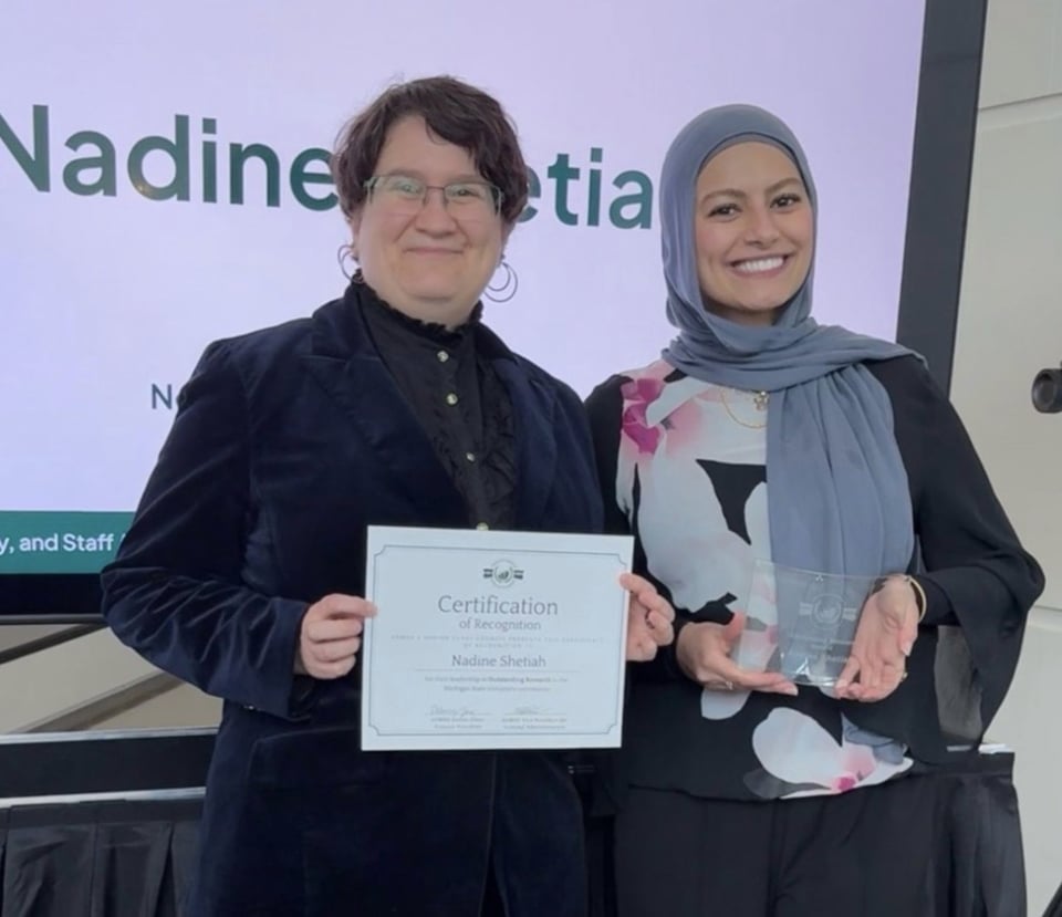 Professor Ariel Cascio and Nadine Shetiah standing with an award together