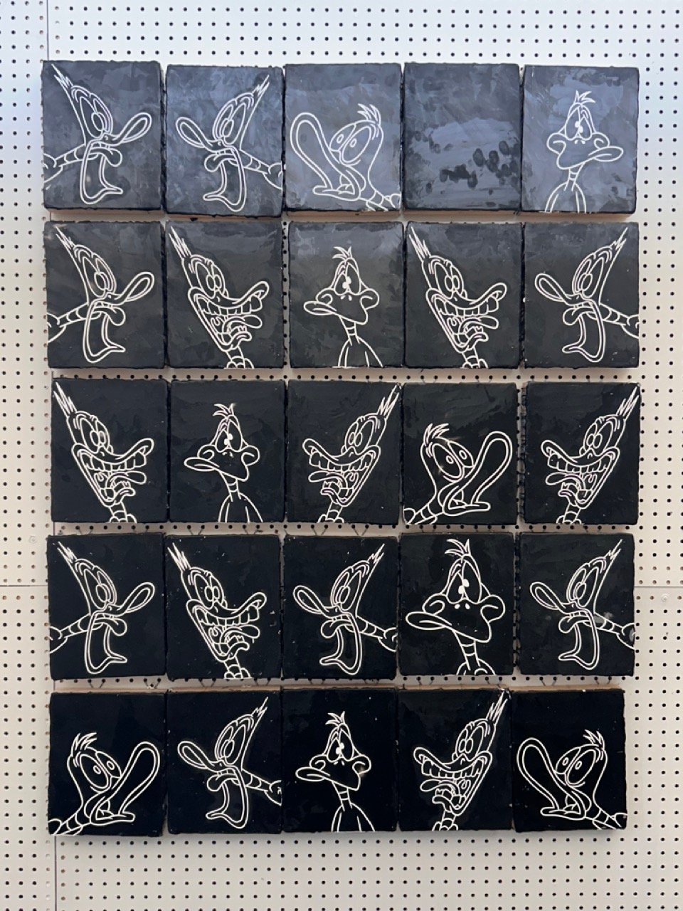 25 panels with 24 screaming cartoon ducks. White on black.