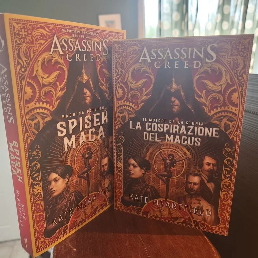 Two paperback copies of Assassin's Creed: The Magus Conspiracy in Polish (Spisek Maga) and Italian (La Cospirazione Del Magus)