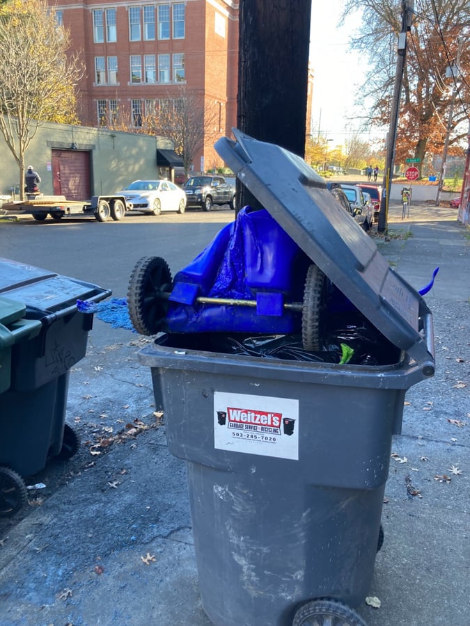 A melted trash can inside another non-melted trash can