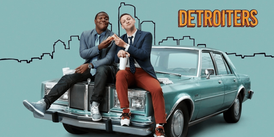 Sam and Tim sit on the hood of a car.