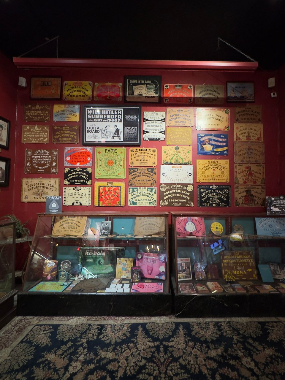 Room with Ouija boards in display cases and on the walls