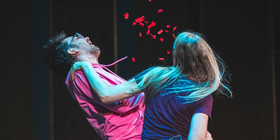 Dan gets punched on stage and red confetti goes flying.