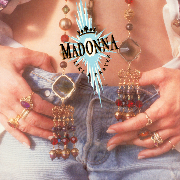 A close up of Madonna's exposed belly and crotch of her jeans. The top buttons of the jeans are unbuttoned. Madonna's hands are on top of her jeans, her thumbs tucked inside. Two long pieces of jewelry hang (presumably) from her neck, strings with various gems and baubles and rings on them. They probably have Catholic significance but I do not know what. If you want to see Madonna's face, cf. Ciccone Youth, THE WHITEY ALBUM.
