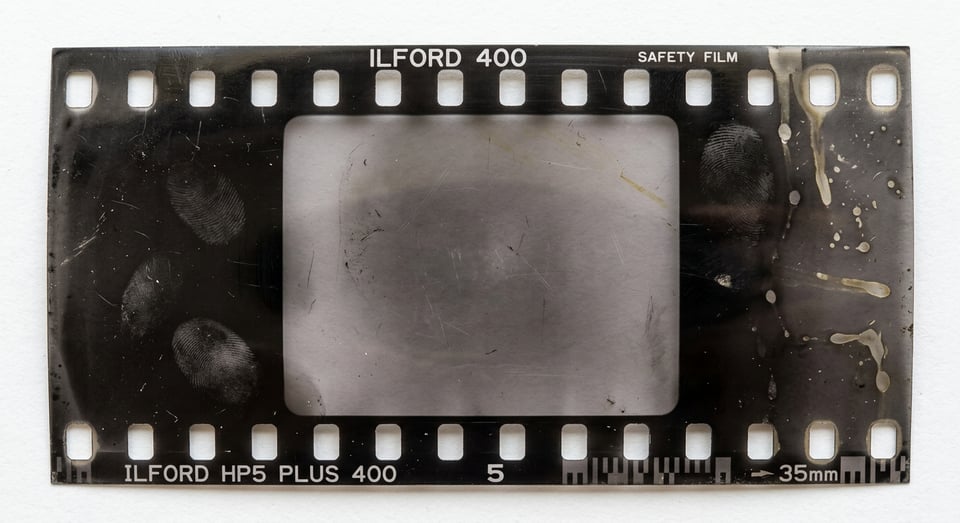 Negative frame with finger prints and chemical stains, image frame empty.