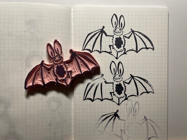 my rubber bat stamp next to several test prints