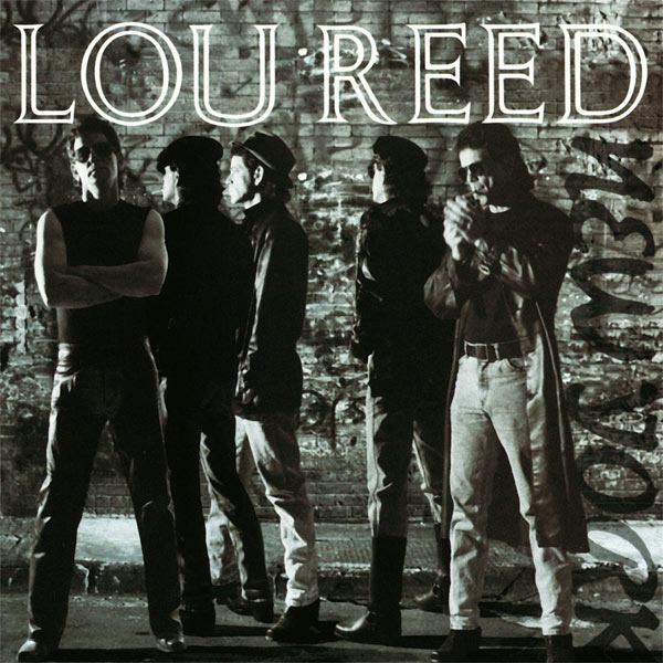 A black and white photo of five Lou Reeds, standing near a brick wall and sidewalk. They're all white guys with black hair who emanate New York cool. Starting from the left: one is in a black wifebeater and sunglasses and looks at the camera, his arms crossed defiantly. The next two are looking to the left; they wear hats and dark jackets. The fourth has his back to us; he wears a hat and sunglasses. The fifth is facing us but is focused on lighting the cigarette in his mouth. He wears sunglasses, a long black jacket, and blue jeans with a belt.