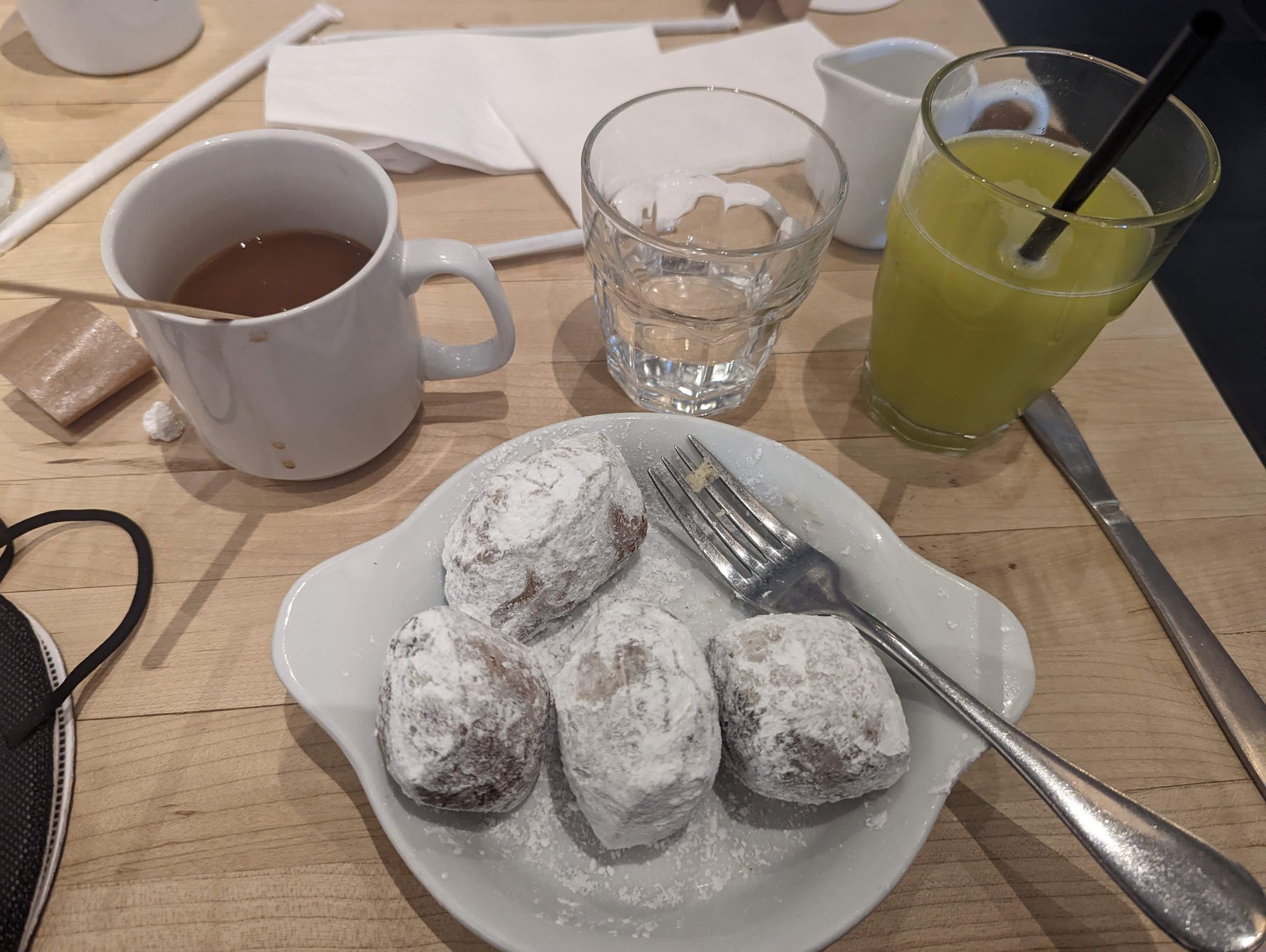 A plate of beignets, plus green juice and hot coffee