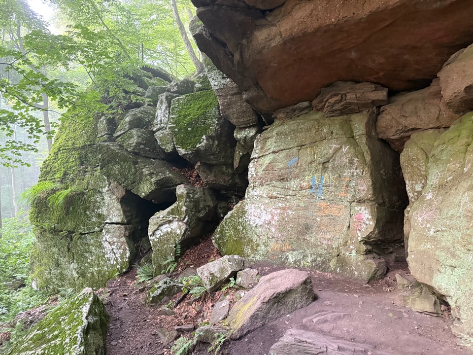 photo of caves and a rock outcropping, with fog in the background