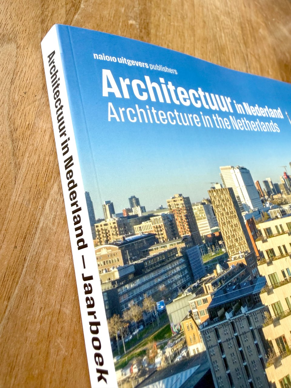 Photo of the architecture book. Top left corner and the spine is visible. On the cover: some aerial photo of buildings. The title is white on the blue sky, set in Action Text.