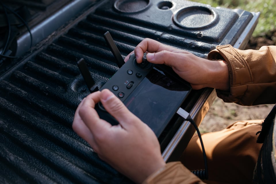 A close-up shot of hands operating a drone controller.