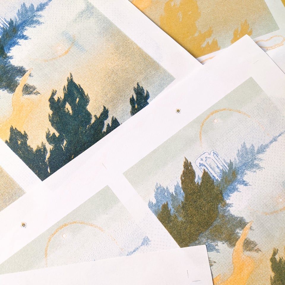 layered riso test prints in shades of blue-green and yellow, showing trees & a ruin reflecting over water