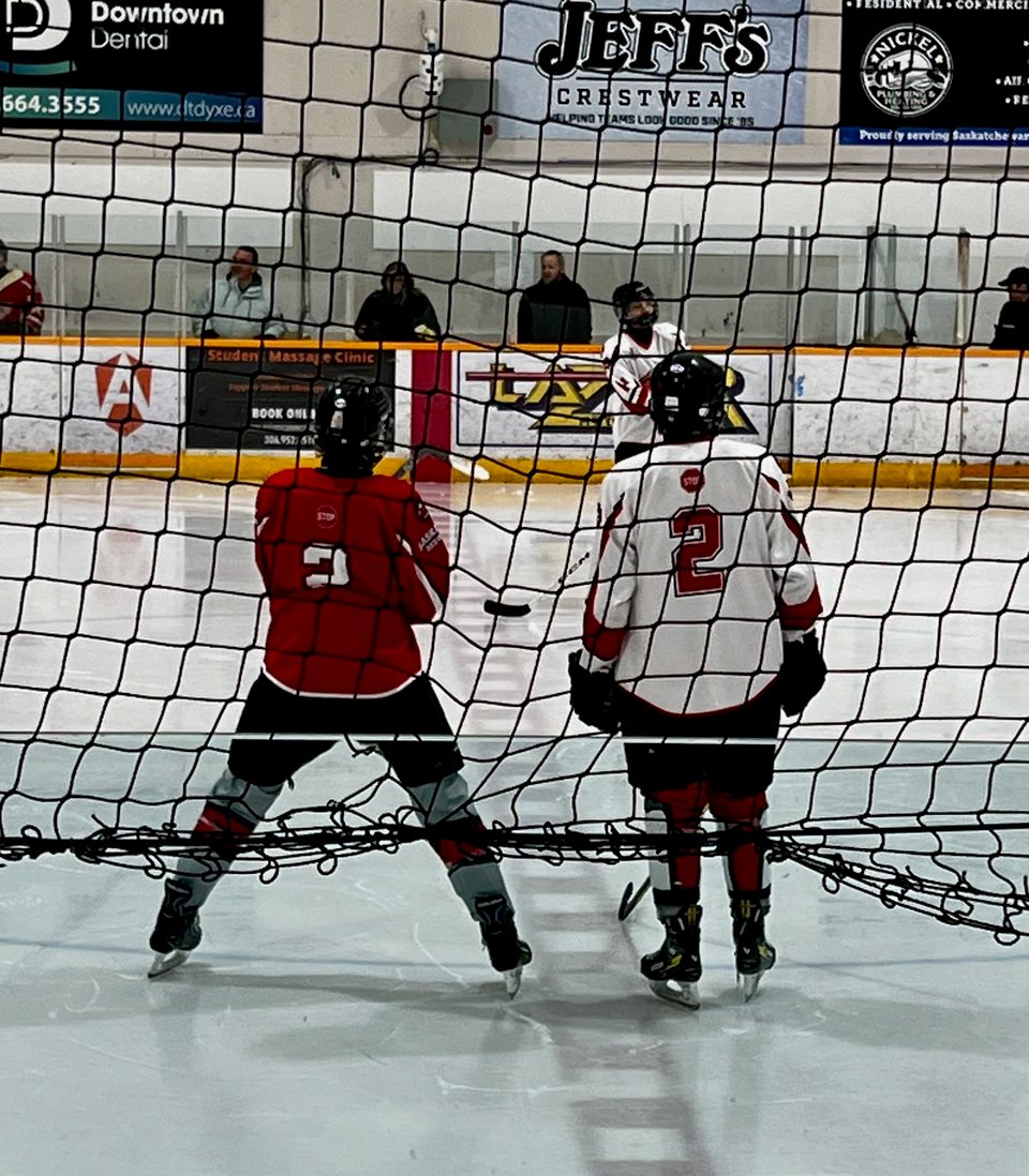 a hockey game with two players with their backs to the camera, both have the #2 on their back