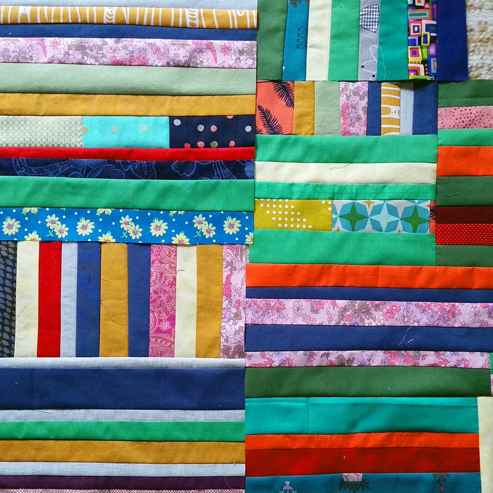 Photo of Under the Whelm, 2018 by Sarah Atlee, in progress. There are stripes of fabric in every color.