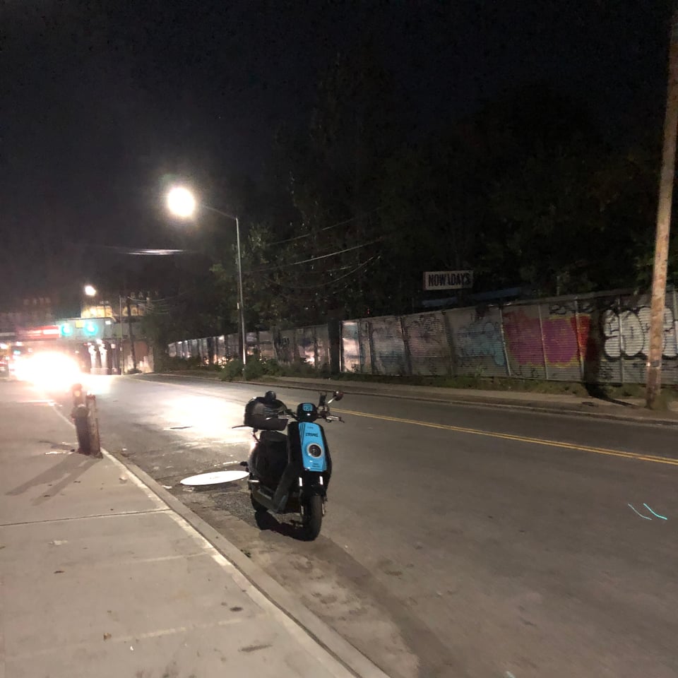 a revel scooter parked on a street at night