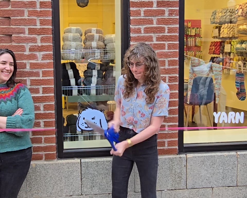 picture of hannah cutting a pink cord with her scissors