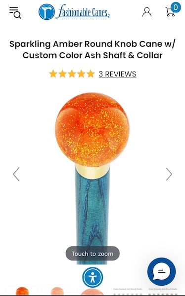 Teal cane with a glittery orange ball atop it