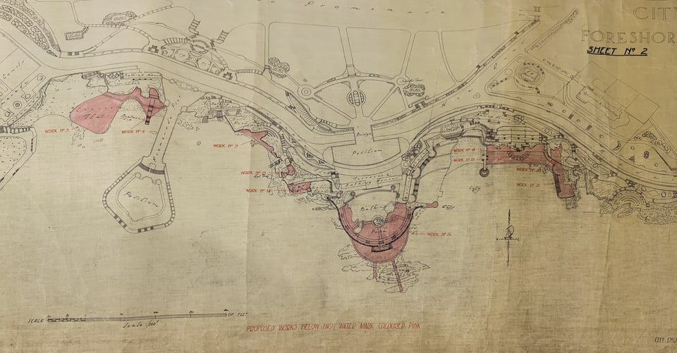 A hand drawn map of Plymouth foreshore showing two coves. There's a large semi-circular pool on the promontory between the two, and lots of terraces and concrete platforms. Parts are shaded pink.