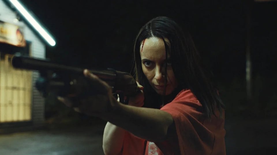 Kate O'Flynn as Patricia, holding a shotgun, a thin trickle of blood running down her forehead, in Widow's Bay episode eight.